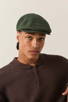 Unisex Hooligan Flat Cap in the color Moss/Orange - Men's Side View